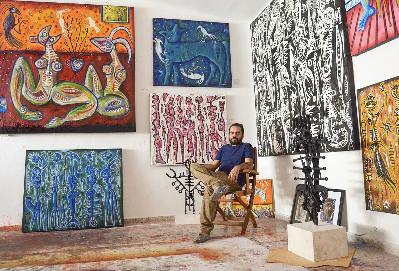 El joven artista plástico Carlos Génova con algunas de sus obras.